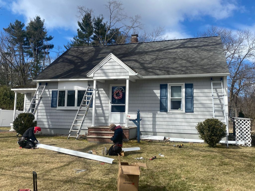JM Exteriors Roofing Siding's roofers are preparing materials for a professional gutter installation in Chelmsford, MA. Our team ensures your home’s foundation and siding are defended from water damage with flawless drainage solutions.