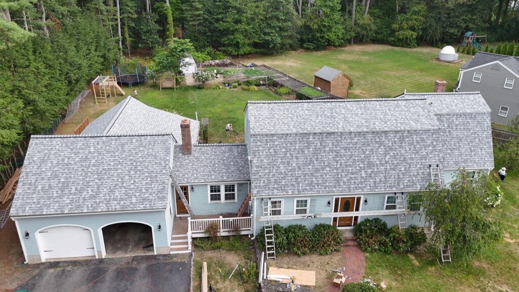 Aerial view of a large residential roof installation in Andover, MA, completed by GAF and Owens Corning Preferred Contractors.